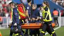 Pemain Paris Saint-Germain (PSG), Neymar, ditandu keluar lapangan saat cedera setelah berebut bola dengan pemain Lille, Benjamin Andre, pada laga Liga Prancis di Stadion Parc des Princes, Minggu (19/2/2023). (AP Photo/Christophe Ena)