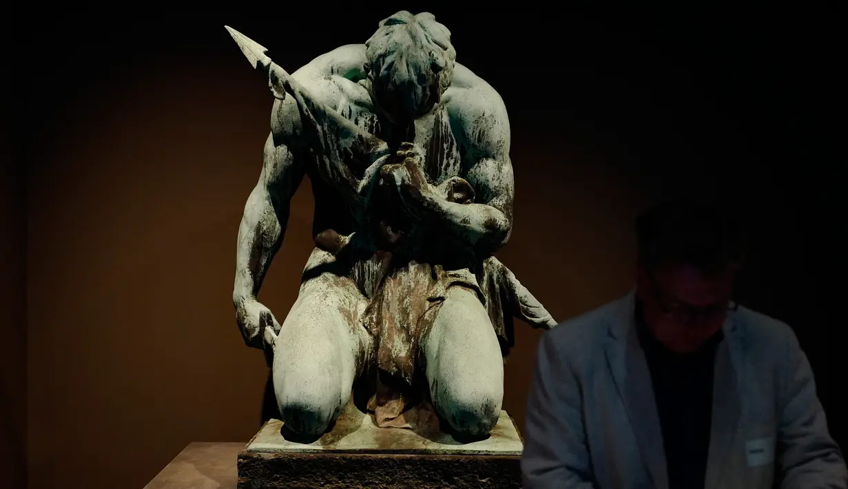 Pengunjung disamping patung yang merupakan bagian dari Monumen Pekerja the Fallen Railway (1928 ) dipamerkan di museum Spandau Citadel, Berlin, (27/4). Pameran ini menggambarkan sejarah Jerman melalui banyak monumen. (John MacDougall / AFP)