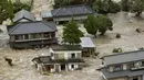 Warga yang terjebak luapan banjir dari Sungai Kinugawa di Joso, prefektur Ibaraki, menunggu dievakusi tim penyelamat, Jepang, Kamis (10/9). Satu orang hilang dan lebih dari 90 ribu warga diperintahkan untuk mengungsi. (REUTERS/Kyodo)