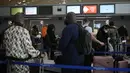 Pelancong ke Amerika Serikat menunggu di meja check-in di bandara Charles de Gaulle, utara Paris, Senin (8/11/2021).  AS pada Senin mencabut pembatasan perjalanan dari daftar panjang negara termasuk Meksiko, Kanada, dan sebagian besar Eropa. (AP Photo/Christophe Ena)