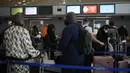 Pelancong ke Amerika Serikat menunggu di meja check-in di bandara Charles de Gaulle, utara Paris, Senin (8/11/2021). AS pada Senin mencabut pembatasan perjalanan dari daftar panjang negara termasuk Meksiko, Kanada, dan sebagian besar Eropa. (AP Photo/Christophe Ena)