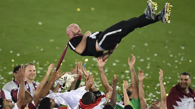 Pelatih Qatar, Felix Sanchez diterbangkan pemainnya usai mengantar tim asuhannya jadi juara Piala Asia 2019. (AFP/Khaled Desouki)