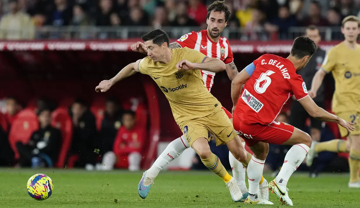 Penyerang Barcelona Robert Lewandowski berebut bola dengan gelandang Almeria Cesar de la Hoz pada pekan ke-23 Liga Spanyol di Power Horse Stadium, Senin dini hari WIB (27/2/2023). Sedangkan, Barcelona dengan kekalahan ini gagal memanfaatkan kesempatan untuk menjauhi Real Madrid dan hanya unggul tujuh angka. (AP Photo/Jose Breton)