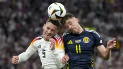 Pemain Jerman, Pascal Gross (kiri) berduel udara dengan pemain Skotlandia, Ryan Christie pada laga pembuka Grup A Euro 2024 di Allianz Arena, Munchen, Jerman, Sabtu (15/06/2024) WIB. (AP Photo/Antonio Calanni)