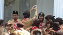 Seorang wanita dari delegasi gerakan Pramuka Indonesia tampak berselfie ria di Halaman Istana Merdeka, Jakarta, Jumat (24/7/2015). Presiden Jokowi juga menghadiri acara pelepasan 462 kontingen Pramuka Indonesia ke jepang. (Liputan6.com/Faizal Fanani)