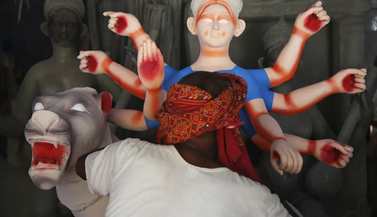 Pematung Nepal Puran Pandit memberikan sentuhan akhir pada patung dewi Hindu Durga menjelang festival Dashain di Kathmandu, Nepal (14/10/2020). Keluarga Pandit akan menjual setidaknya 200 patung untuk festival ini, tetapi tahun ini hanya menjual 20 patung karena pandemi. (AP Photo/Niranjan Shrestha)