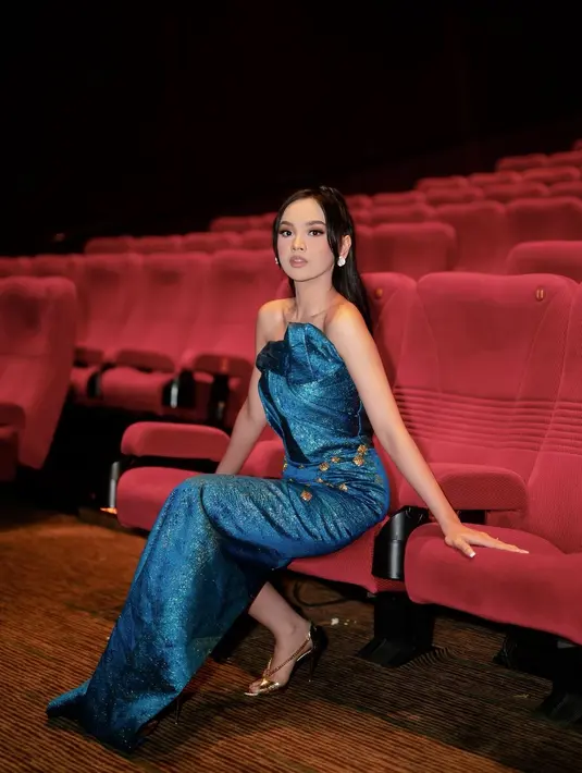 Gaunnya semakin mewah dengan detail beads emas yang menghiasi bagian rok gaunnya. Lyodra kemudian menyelesaikan penampilannya dengan half updo hairstyle dan anting-anting sebagai aksesori. [@lyordraofficial],