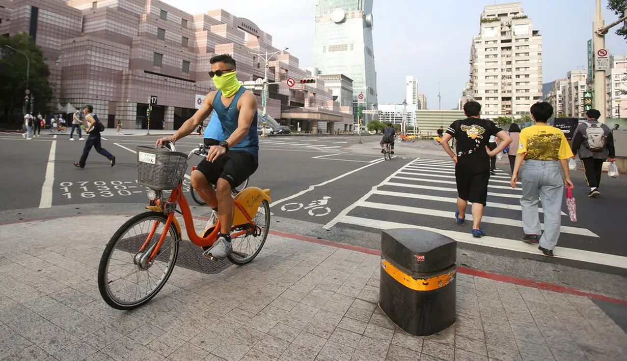 Warga memakai masker untuk melindungi diri dari penyebaran COVID-19 di Taipei, Taiwan, Sabtu (15/5/2021). Taiwan yang telah berhasil membuat iri dalam menahan COVID-19 memberlakukan pembatasan baru di ibu kotanya saat memerangi wabah terburuk sejak pandemi dimulai. (AP Photo/Chiang Ying-ying)