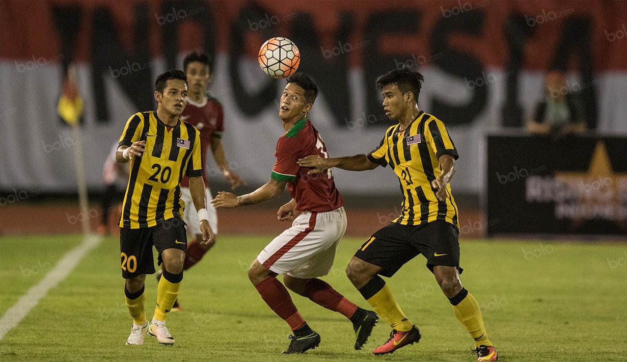 Penyerang Indonesia, Irfan Bachdim, berusaha melewati hadangan pemain Malaysia pada laga persahabatan di Stadion Manahan, Solo, Jawa Tengah, Selasa (6/9/2016). Indonesia menang 3-0 atas Malaysia. (Bola.com/Vitalis Yogi Trisna)