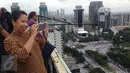 Menteri BUMN, Rini Soemarno mengabadikan gambar demo 2 Desember di atas gedung BUMN, Jakarta, Rabu (2/12). Demo 2 Desember digelar sebagai lanjutan dari aksi 4 November 2016. (Liputan6.com/Ferbian Pradolo)