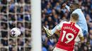 Gelandang Manchester City, Jeremy Doku (belakang) melepaskan tendangan di bawah tekanan gelandang Arsenal, Leandro Trossard pada laga pekan ke-30 Premier League 2023/2024 di Etihad Stadium, Manchester, Minggu (31/3/2024). (AP Photo/Dave Thompson)