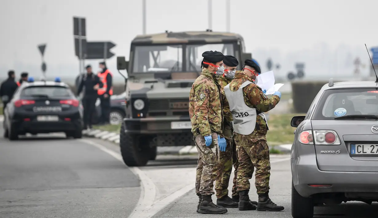 Prajurit dan polisi Angkatan Darat Italia memeriksa kendaraan yang masuk dan keluar daerah yang dikunci terkait virus corona atau COVID-19 dekat Turano Lodigiano, Italia, Selasa (25/2/2020). Tujuh pasien terinfeksi virus corona atau COVID-19 di Italia dinyatakan meninggal. (Claudio Furlan/Lapresse v
