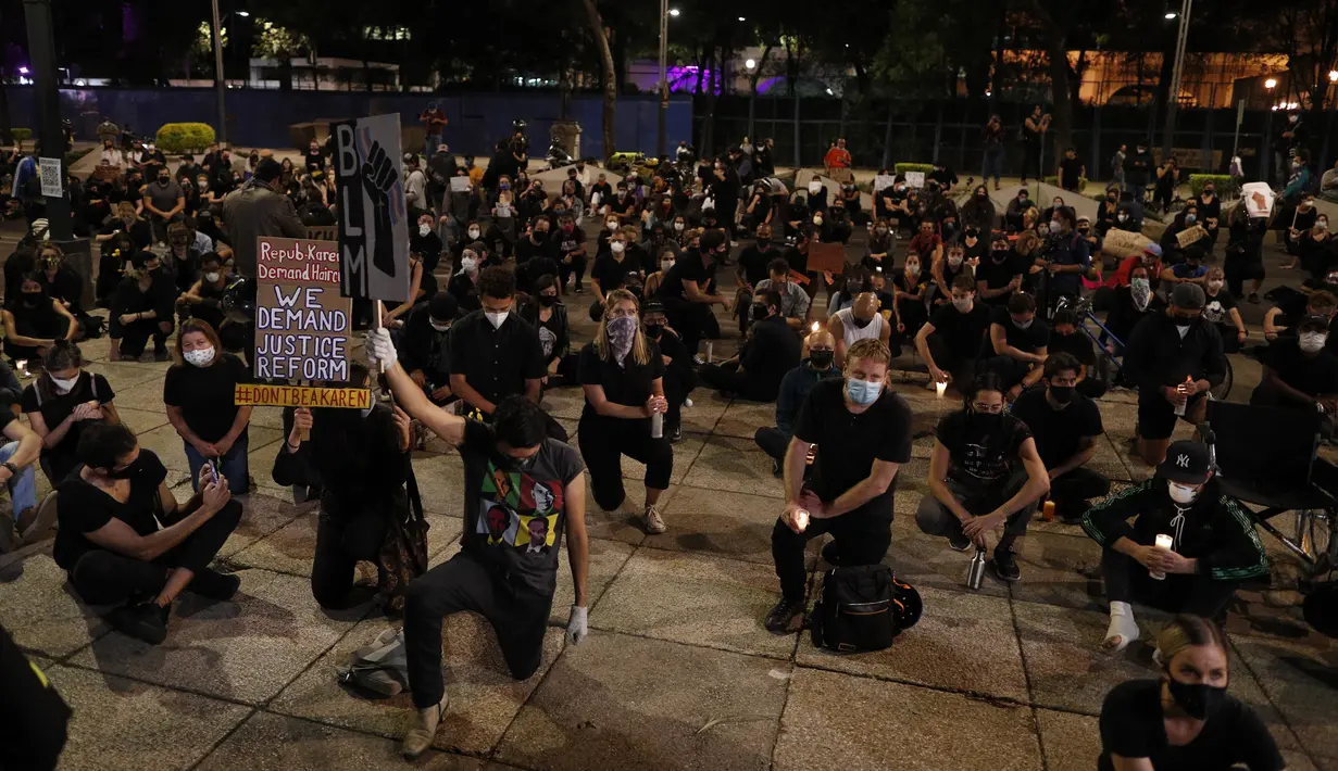 Demonstran berlutut saat memprotes kematian George Floyd di luar Kedutaan Besar AS di Mexico City, Meksiko, Kamis (4/6/2020). Kematian pria kulit hitam George Floyd saat ditangkap oleh polisi Amerika Serikat memicu kemarahan di sejumlah negara. (AP Photo/Rebecca Blackwell)