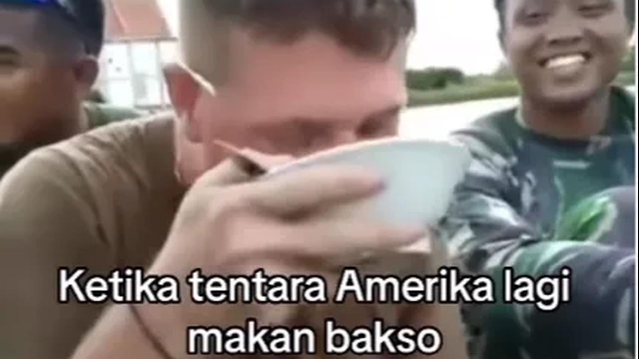 Tak mengerti bahasa yang digunakan kawannya, tentara itu kembali menikmati semangkuk baksonya. Saking lahapnya, dia bahkan tak segan untuk menyeruput kuah bakso di mangkuk.<br>