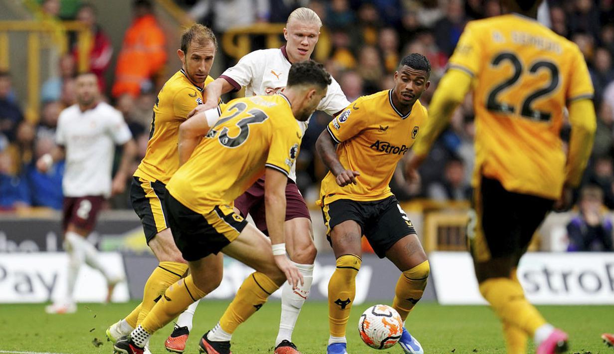 Para pemain Wolverhampton Wanderers menjaga ketat pemain Manchester City, Erling Haaland, pada laga Liga Inggris di Stadion Molineux, Minggu (1/10/2023). City takluk dengan skor 1-2. (Nick Potts/PA via AP)