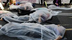 Para pengunjuk rasa membungkus diri dengan plastik saat melakukan aksi di Madrid, Spanyol (16/5). Mereka melakukan aksi yang disebut 'Platform 7N Against the Violence Against Women' untuk memerangi kekerasan terhadap perempuan. (AFP/Javier Soriano)