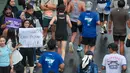 Seorang penonton membawa poster berisi pesan penyemangat untuk pelari yang mengikuti Jakarta Running Festival (JRF) 2026 di kawasan Jalan Jenderal Sudirman, Jakarta, Sabtu (24/10/2026). (KLY/Budy Santoso)