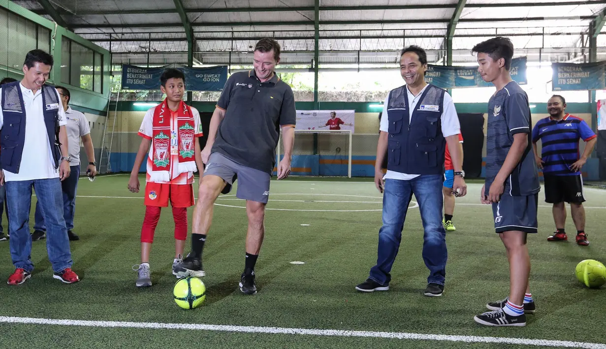 Legenda Liverpool Vladimir Smicer (tengah) didampingi Manajemen AXA Mandiri Hartono dan Preskom AXA Mandiri Agus Haryoto Widodo menggiring bola pada pembukaan sharing and learning di Grand Futsal, Jakarta, Jumat (8/2). (Liputan6.com/Fery Pradolo)