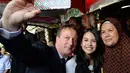Dalam kunjungannya, David Cameron ditemani penyanyi cantik Maudy Ayunda. Mereka melakukan foto selfie bersama ibu pemilik warung. (via dailymail.co.uk)