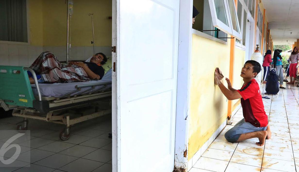 Pasien menjalani perawat saat relawan membersihkan sisa lumpur yang menggenangi RSUD dr Slamet akibat banjir bandang di Kabupaten Garut, Kamis (22/9). Pasca diterjang banjir bandang, peralatan perlengkapan RSUD dr Slamet rusak. (Liputan6.com/Johan Tallo)