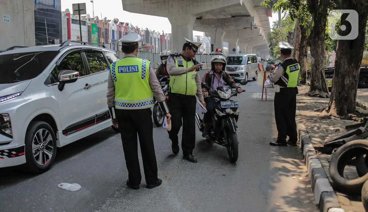 Polisi lalu lintas memberhentikan pengendara sepeda motor saat pelaksanaan Operasi Zebra Jaya 2019 di Jalan Boulevard Gading Raya, Jakarta, Kamis (24/10/2019). Polda Metro Jaya menggelar Operasi Zebra Jaya hingga 5 November mendatang guna menekan pelanggaran lalu lintas. (Liputan6.com/Faizal Fanani)