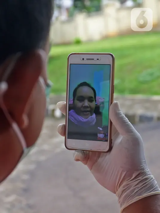 Pasien sembuh COVID-19 melakukan video call usai meninggalkan ruangan isolasi Graha Wisata Ragunan di Jakarta, Jumat (29/1/2021). Data Satgas Covid-19 per Jumat (29/1), jumlah pasien yang sembuh bertambah 10.138 orang dengan total pasien sembuh mencapai 852.260 orang. (Liputan6.com/Herman Zakharia)