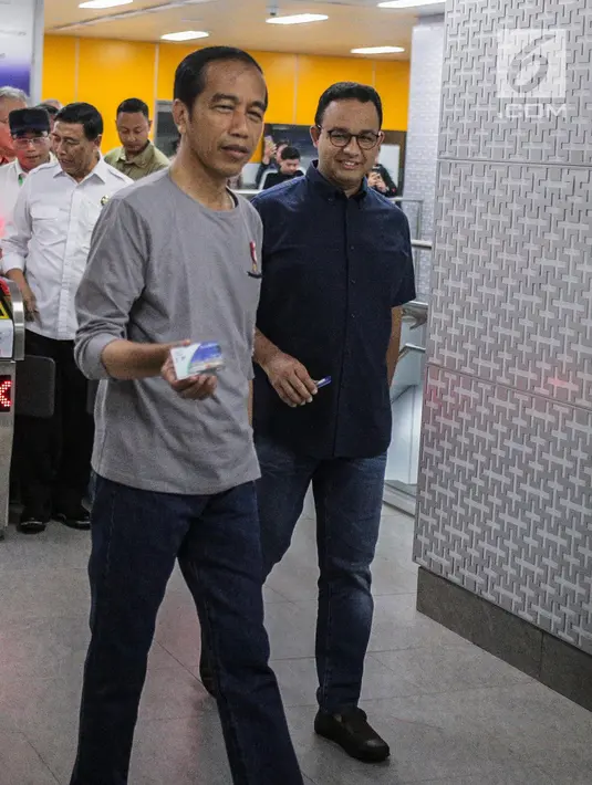Presiden Joko Widodo menunjukkan tiket masuk untuk menaiki moda raya terpadu (MRT) di Stasiun MRT Istora Mandiri, Jakarta, Minggu (24/3). Jokowi tampil santai pakai celana Jeans, kaos dan sepatu Kets. (Liputan6.com/Faizal Fanani)