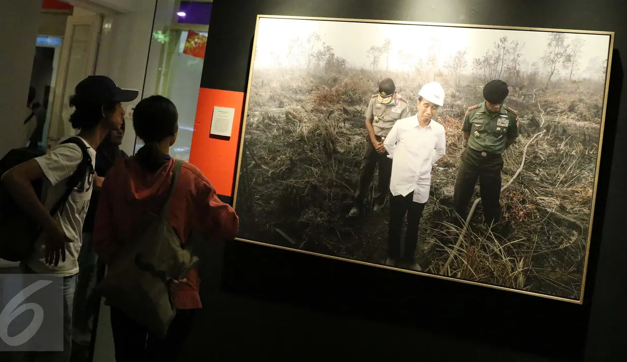 Pengunjung mengamati foto Jokowi yang terpampang dalam roadshow pameran foto APFI 2016 di Galeri Foto Jurnalistik Antara, Jakarta, Minggu (9/10). Pameran ini digelar setiap tahun (Liputan6.com/Gempur M. Surya)