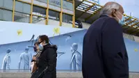 Pejalan kaki yang mengenakan masker melintas di depan stasiun metro di Athena, Senin (15/11/2021). Pihak berwenang mengatakan kematian COVID-19 di Yunani mencapai tingkat tertinggi dalam enam bulan karena sekitar sepertiga dari populasi negara itu belum divaksinasi. (AP/Thanassis Stavrakis)