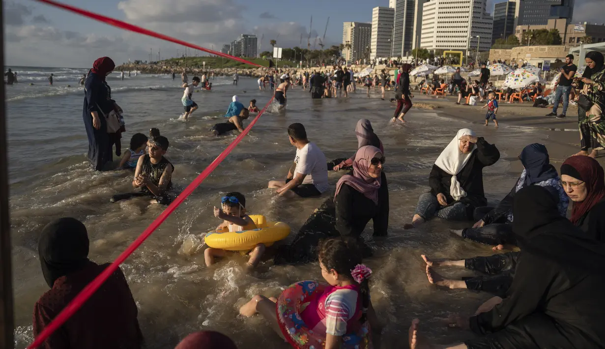 Warga Palestina berbaur dengan warga Israel di pantai Tel Aviv. (AP Photo/Oded Balilty)