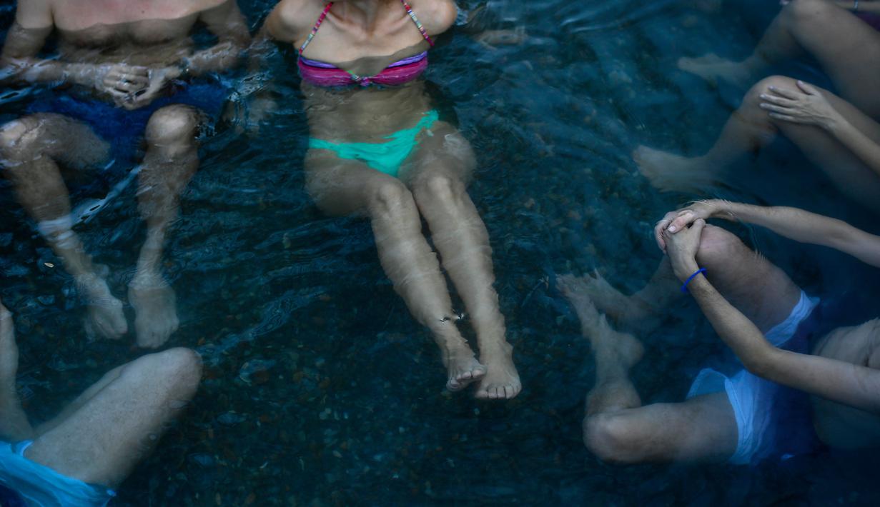 Pengunjung menikmati pemandian air panas alami Sungai Cidaco dengan suhu 52 Celcius saat pagi musim dingin di desa kecil Arnedillo, Spanyol utara, 29 Desember 2018. (AP Photo/Alvaro Barrientos)