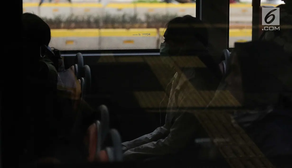 Seorang wanita memakai masker pelindung saat berada di dalam bus untuk menghidari polusi udara buruk di Jakarta, Rabu (17/7/2019). Dinkes DKI menyarankan masyarakat untuk menggunakan masker saat beraktivitas untuk mencegah dampak polusi udara pada tubuh. (Liputan6.com/Faizal Fanani)