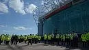 Petugas keamanan berjaga di luar Stadion Old Trafford, usai penemuan benda mencurigakan di salah satu tribun, Inggris, Minggu (15/5). Penemuan benda mencurigakan itu membuat Laga terakhir Liga Inggris antara MU Vs Bournemouth ditunda. (Oli SCARFF/AFP)