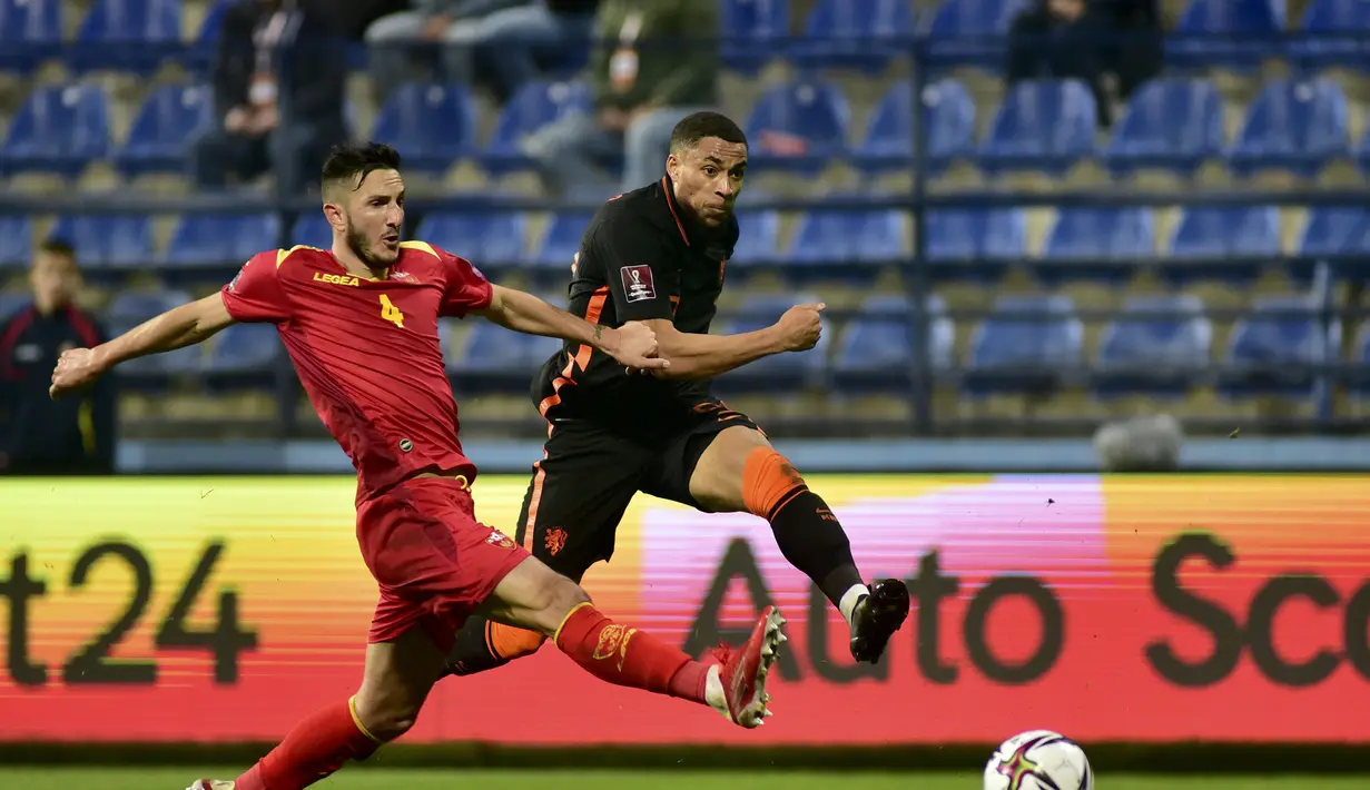 Bek Montenegro, Marko Vukcevic berusaha memblok bola tendangan penyerang Belanda, Arnaut Danjuma pada pertandingan grup G  kualifikasi Piala Dunia 2022 di stadion City di Podgorica, Montenegro, Minggu (14/11/2021). Belanda bermain imbang atas Montenegro 2-2. (AP Photo/Risto Bozovic)