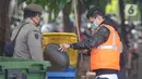 Seorang pelanggar dihukum membersihkan sampah saat Operasi Yustisi Protokol COVID-19 di Kawasan Bundaran HI, Jakarta, Selasa (15/9/2020). Operasi Yustisi itu untuk menegakkan pemakaian masker guna menekan perilaku warga yang memicu angka kenaikan infeksi Covid-19. (merdeka.com/Imam Buhori)