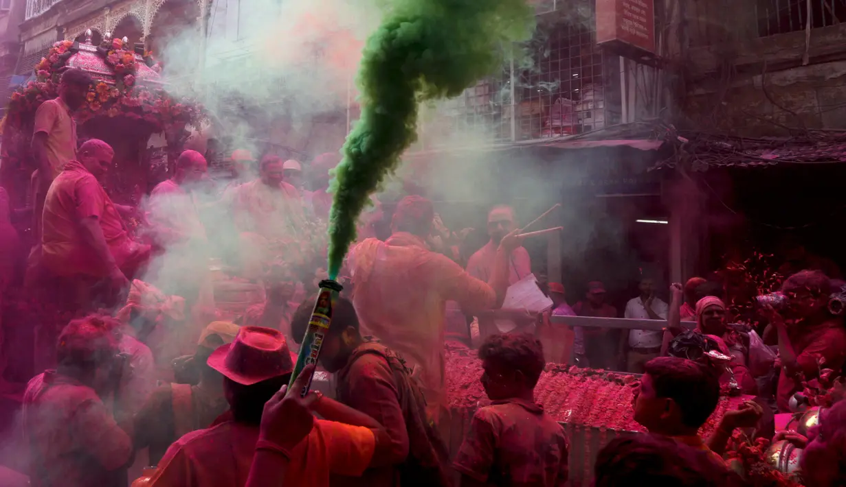 Warga menyalakan lilin asap warna-warni saat merayakan Festival Holi di Kolkata, India, Rabu (28/2). Festival ini juga mendatangi datangnya musim semi. (AP Photo/Bikas Das)