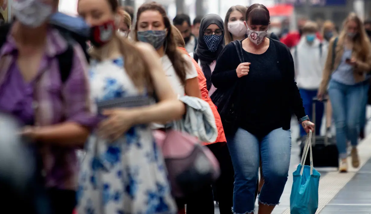 Penumpang berjalan di sepanjang peron di stasiun kereta utama di Frankfurt, Jerman, Jumat (14/8/2020). Mengenakan masker untuk melindungi diri dari corona Covid-19 adalah kewajiban di transportasi umum di Jerman. (AP Photo/Michael Probst)