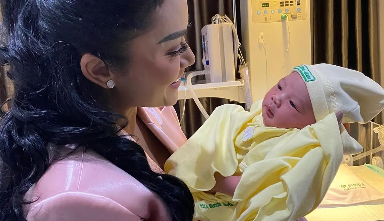 Melalui akun instagramnya, mantan istri Anang Hermansyah itu membagikan potret gendong cucu keduanya. [Instagram/krisdayantilemos]