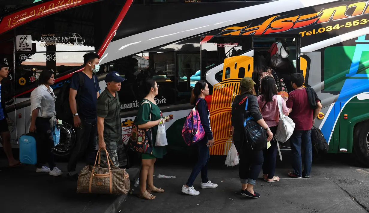 Penumpang bersiap menaiki bus ke kampung halaman mereka di Terminal Bus Mo Chit sehari sebelum Songkran Festival, atau Tahun Baru Thailand, di Bangkok (12/4). (AFP Photo/Lillian Suwanrumpha)