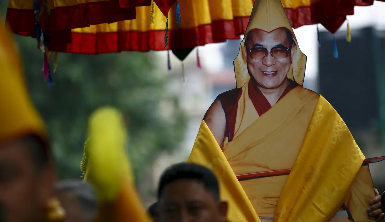 Biksu Tibet membawa poster Dalai lama saat perayaan ulang tahun ke-80 Dalai Lama di Kathmandu, Nepal, (6/7/2015). Dalai lama merupakan nama gelar dari agama Budha, gelar  ini diturunkan secara turun temurun. (REUTERS/Navesh Chitrakar)