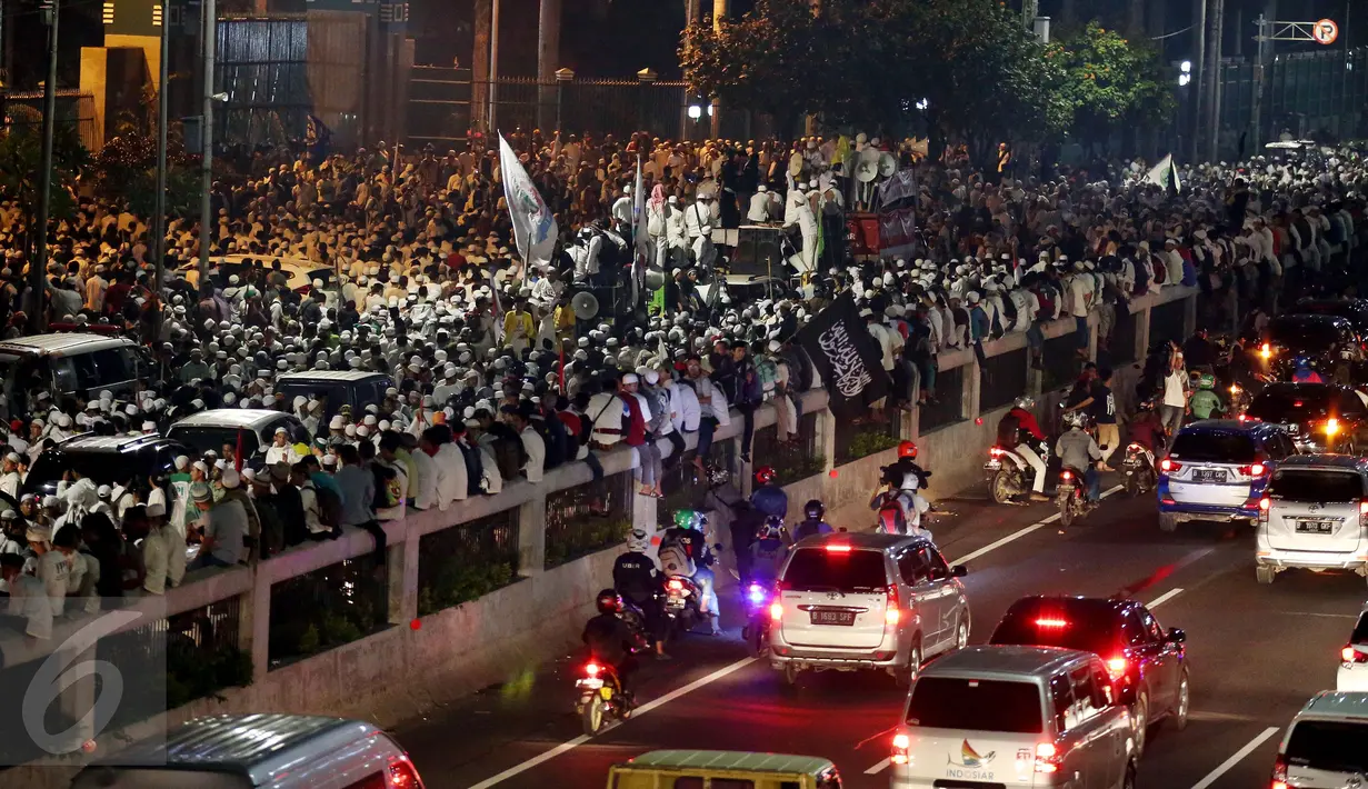 Massa peserta demo 4 November menduduki Jalan Gatot Subroto, Jakarta, atau tepat di depan Gedung MPR/DPR RI, Jumat (4/11). Mereka terpaksa menginap di jalan depan Gedung DPR lantaran tak diizinkan masuk ke dalam komplek parlemen (Liputan6.com/Johan Tallo)