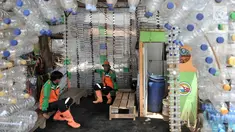 Petugas UPK Badan Air DLH DKI Jakarta bersantai dalam Pos Botol Plastik di Pasar Rebo, Jakarta, Selasa (12/3). Petugas memanfaatkan botol plastik bekas untuk membangun pos cantik. (merdeka.com/Iqbal Nugroho)