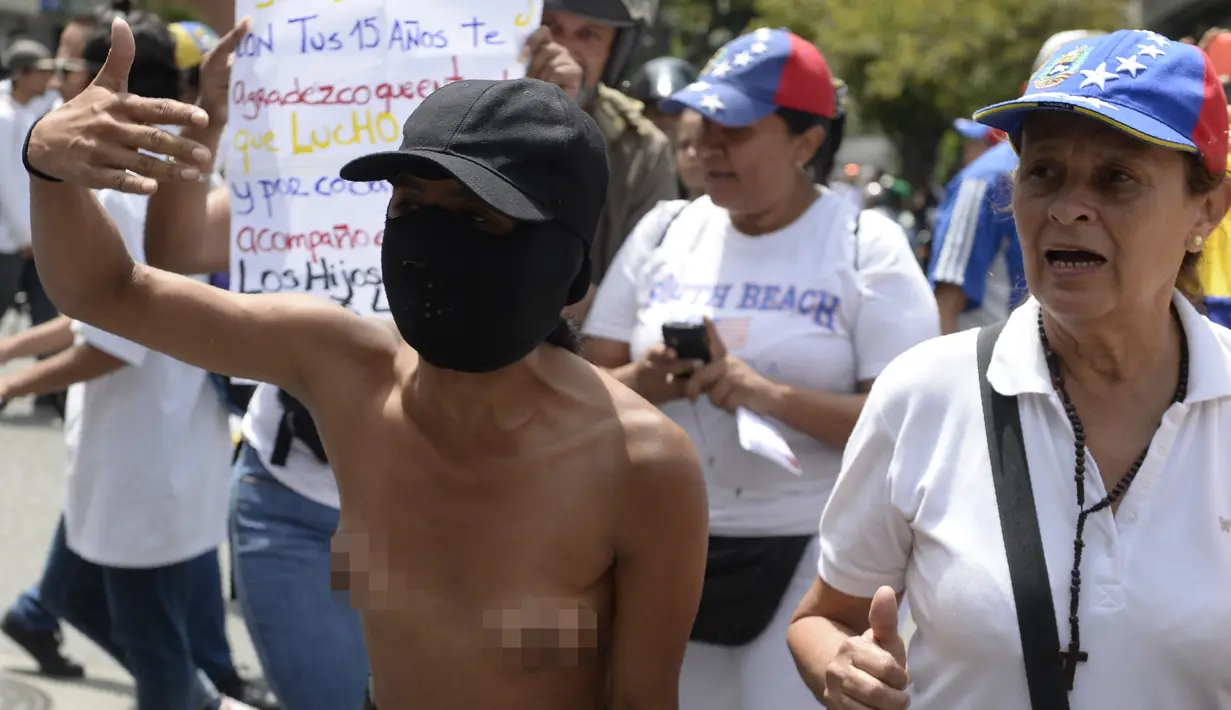Seorang wanita bertelanjang dada sambil berunjuk rasa menentang Presiden Venezuela Nicolas Maduro di Caracas, Sabtu (6/5). Aksi massa wanita itu berlangsung di sejumlah kota besar di negara penghasil minyak di Amerika Selatan. (AFP PHOTO / FEDERICO PARRA)
