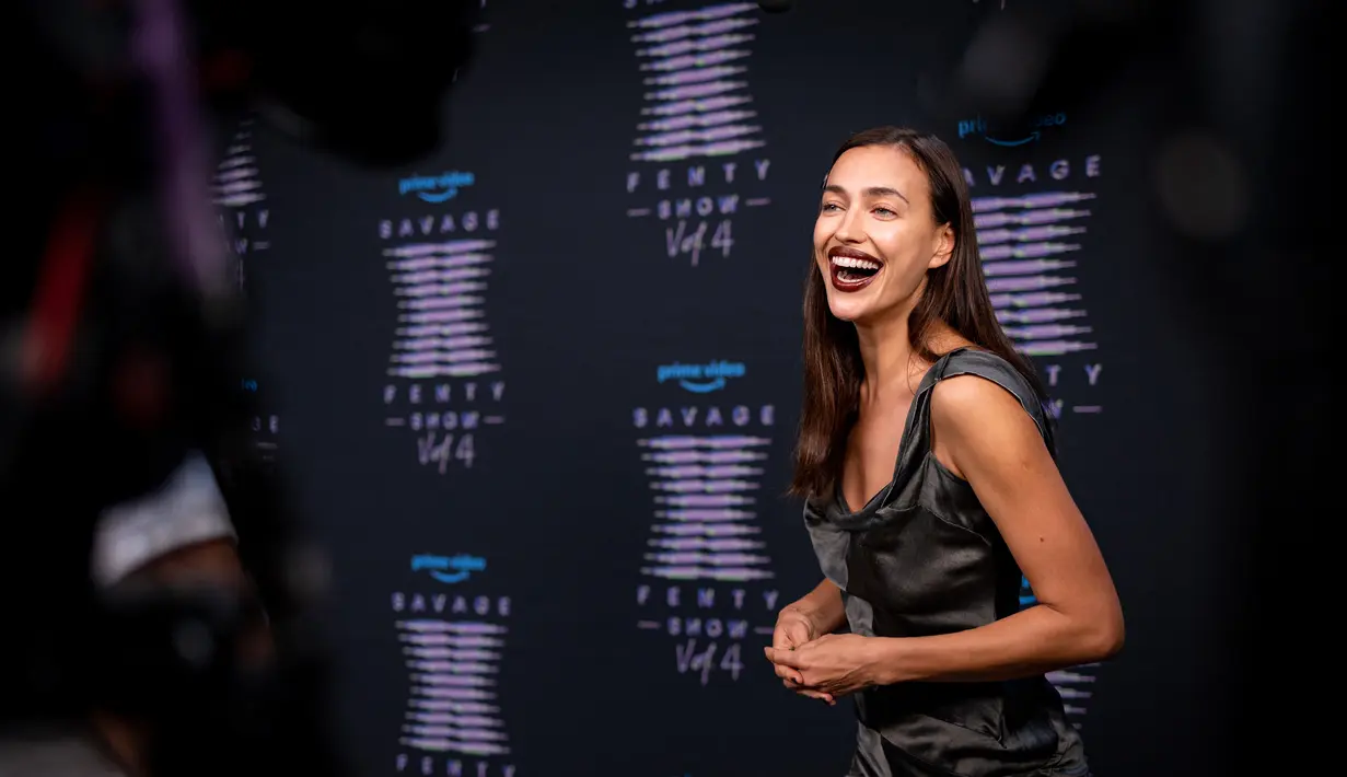 Irina Shayk tertawa saat menghadiri Rihanna's Savage X Fenty Show Vol. 4 disajikan oleh Prime Video di Simi Valley, California; dan disiarkan pada 9 November 2022. Model Rusia itu tampil cantik dengan gaun sutra yang pas.(Matt Winkelmeyer/Getty Images/AFP)