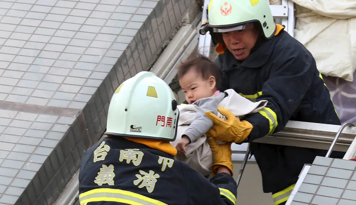 Petugas penyelamat mengevakuasi seorang bayi yang selamat akibat gempa di Tainan, Taiwan Selatan (6/2). Gempa terjadi pukul 4 subuh tadi telah menghancurkan beberapa apartemen di kawasan Wei Guan, Tainan, Taiwan. (REUTERS/Stringer)