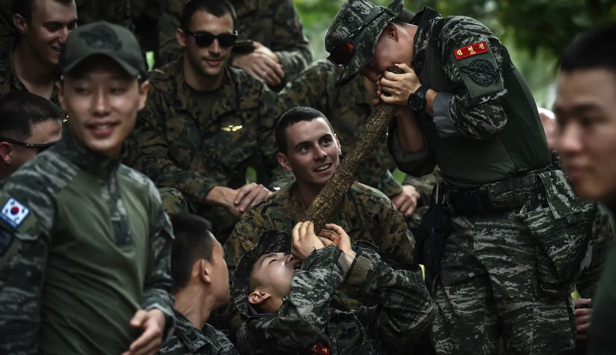 Marinir AS menonton marinir Korea Selatan mengeluarkan air dari pohon anggur selama latihan militer gabungan Cobra Gold antara militer AS dan Thailand di Chonburi, Thailand (19/2). (AFP Photo/Lilian Suwanrumpha)