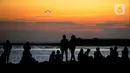 Wisatawan lokal beraktivitas di pantai yang surut dengan latar belakang pesawat di Pantai Kelan, Badung, Bali, Sabtu (22/4/2023). (merdeka.com/Arie Basuki)