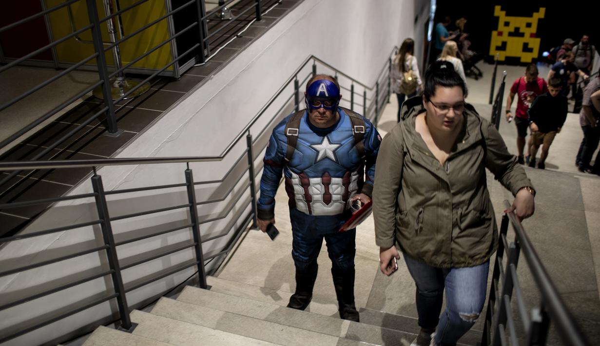Seorang cosplayer berpakaian seperti karakter Marvel Captain America berdiri  di tangga selama International Comic Con di Kyalami Race Course, Johannesburg, Afrika Selatan (14/9). Comic Con digelar pada tahun 1970. (AFP Photo/Marco Longari)