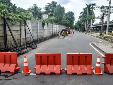 Pekerja Suku Dinas Bina Marga Jakarta Utara menyelesaikan perbaikan jalan jelang gelaran balap liar legal di Jalan Inspeksi Kali Ancol, Pademangan, Rabu (12/1/2022). Polda Metro Jaya resmi menjadikan Jalan Inspeksi Kali Ancol sebagai arena balap liar legal. (merdeka.com/Iqbal S. Nugroho)