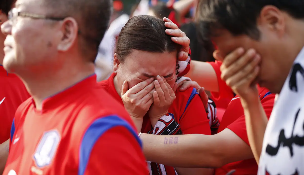 Ekspresi kesedihan tampak pada wajah beberapa warga Korea Selatan usai tim negaranya dikalahkan Belgia 0-1, Seoul, Jumat (27/6/14). (REUTERS/Kim Hong-Ji)